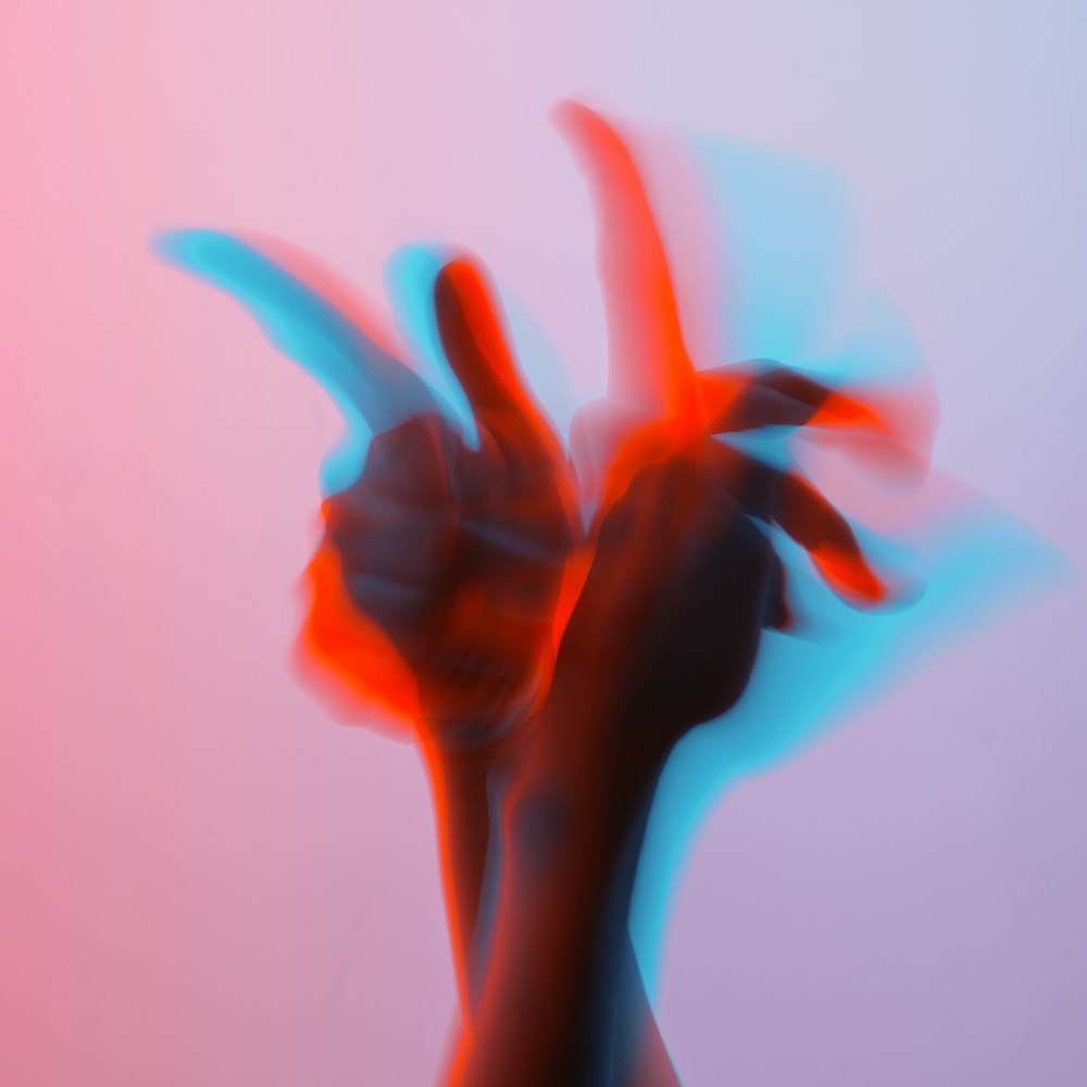 a blurry image of a person's hand making the v sign