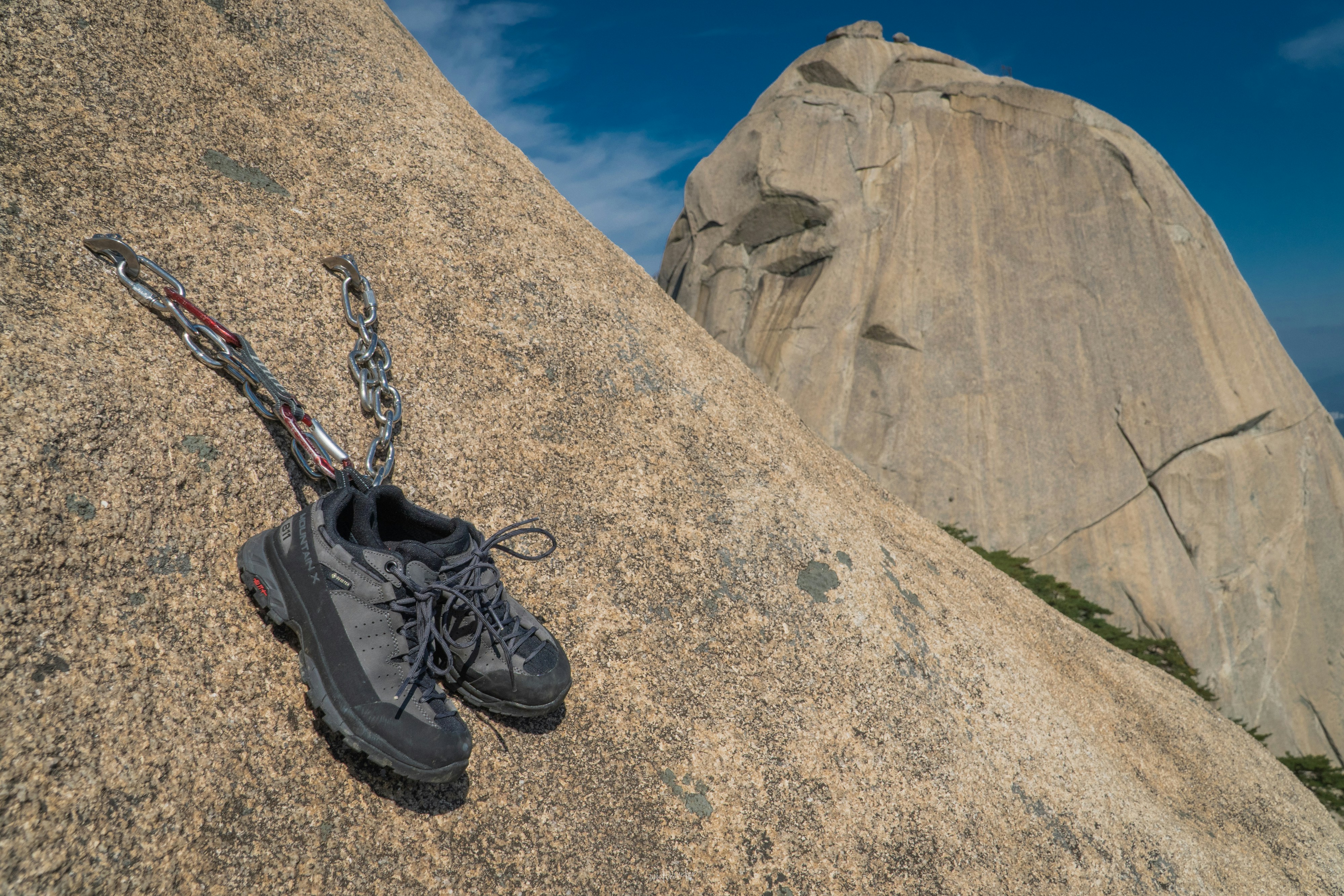 a pair of hiking shoes chained to a rock, 