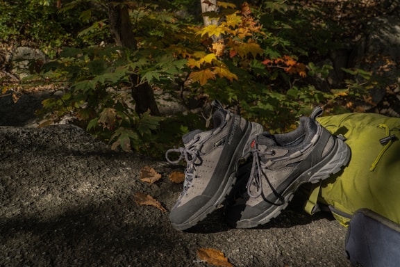Hiker testing different hiking boots on a rocky mountain trail during autumn.