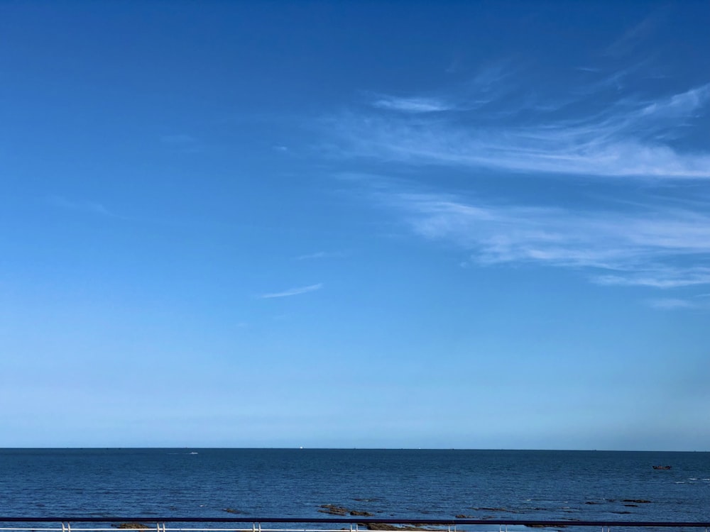 a large body of water sitting under a blue sky