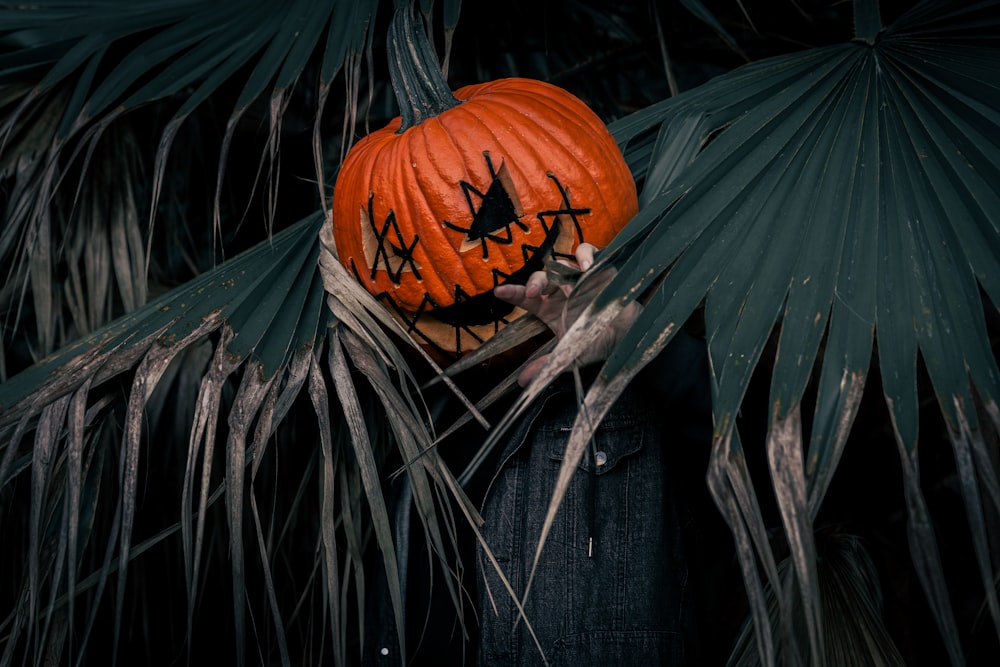 a person wearing a pumpkin face painted on their face