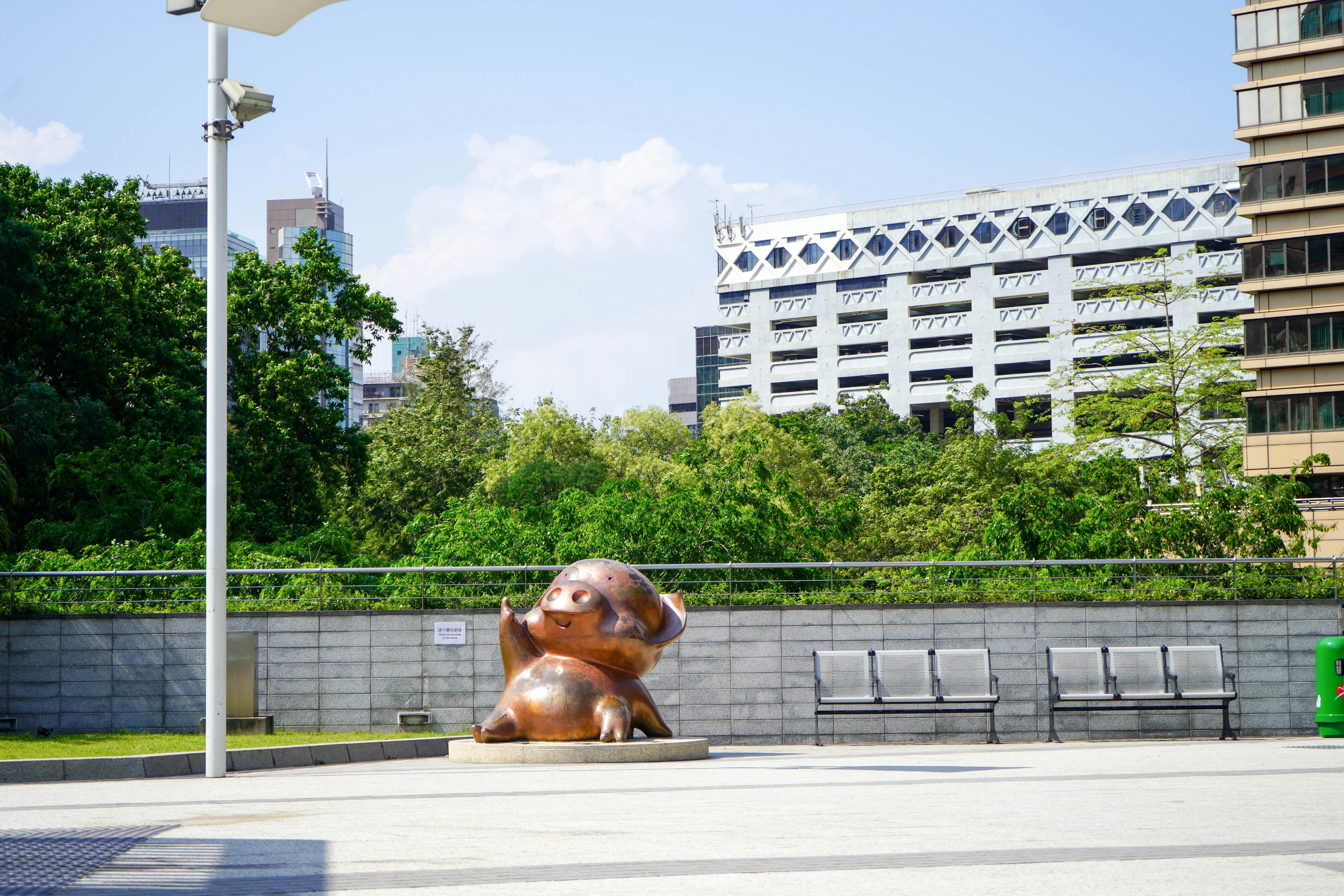 a statue of a bear in a park in front of a building
