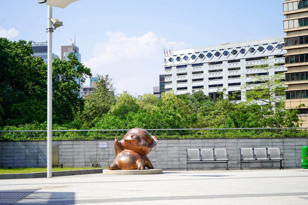 a statue of a bear in a park in front of a building