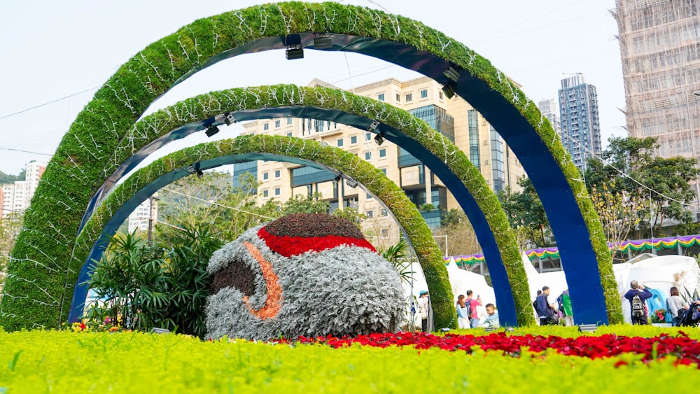 a large fake elephant in the middle of a flower garden