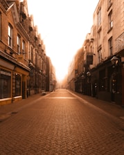 A cozy street scene of The Coombe in Dublin with vintage shopfronts and cobblestones bathed in soft afternoon light.