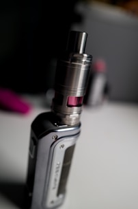 Close-up of a sleek vape pen with a glowing tip on a dark background