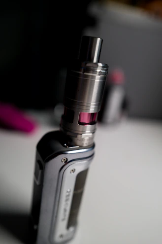 Close-up of a sleek vape device with a matte finish resting on a wooden table in soft natural light.