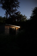 Evening shot of a 40ft shed with warm interior lights glowing through windows.
