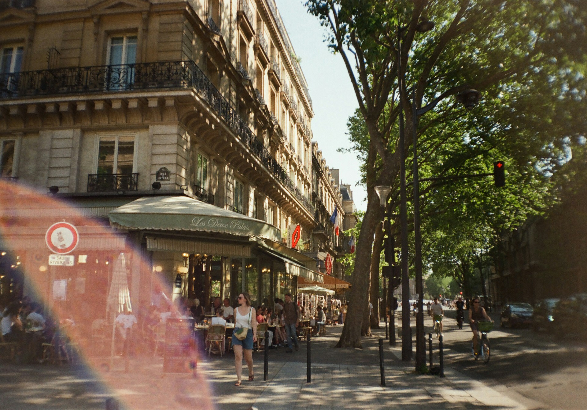 A charming European street scene with colorful buildings, cobblestone paths, and a lively café bustling with people.