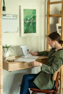 Photo of a student focused and smiling while studying at a wooden desk.