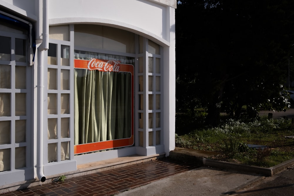 a coca cola store front with a red and white sign