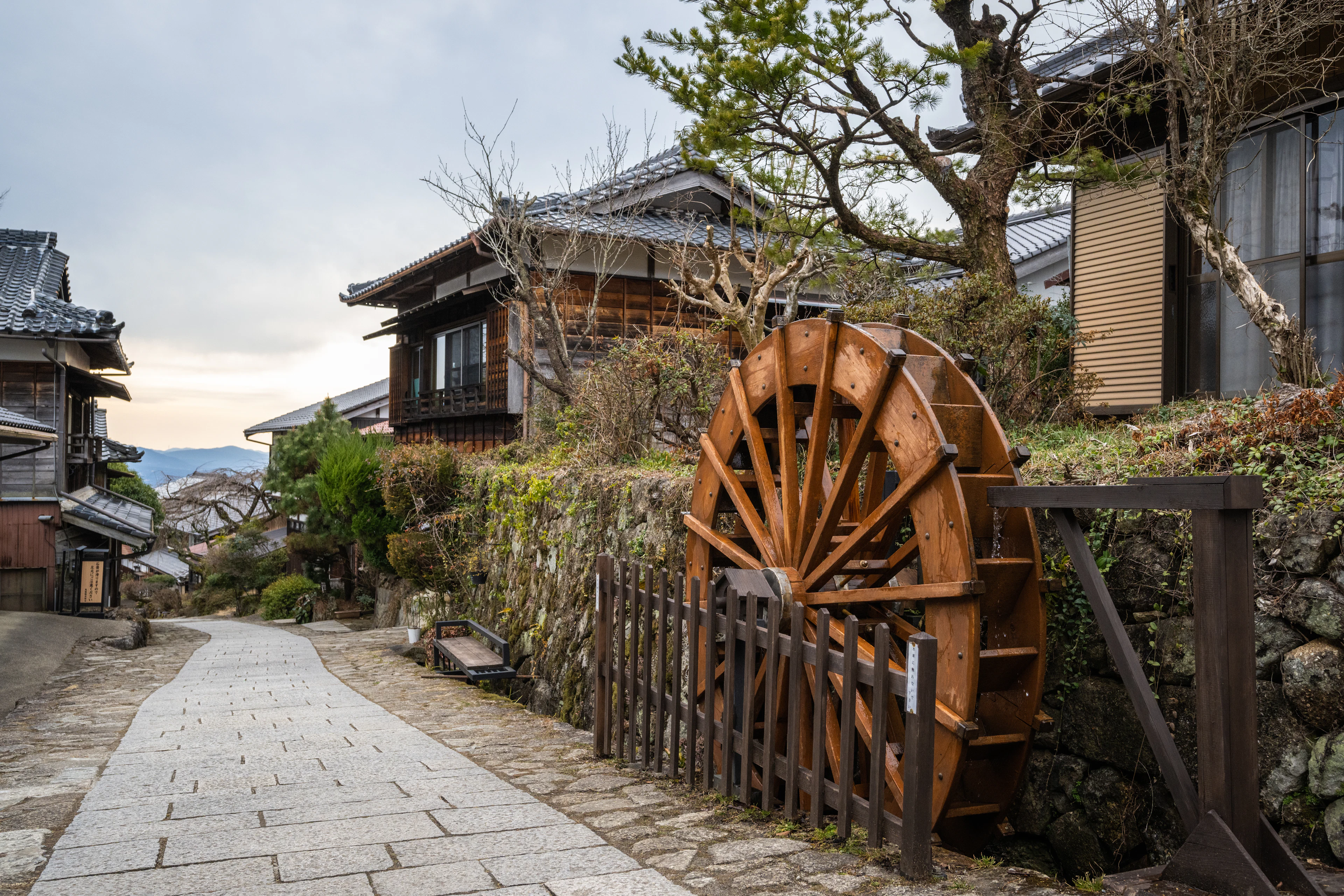A wooden water wheel beside the stone-paved Nakasendo road in Magome