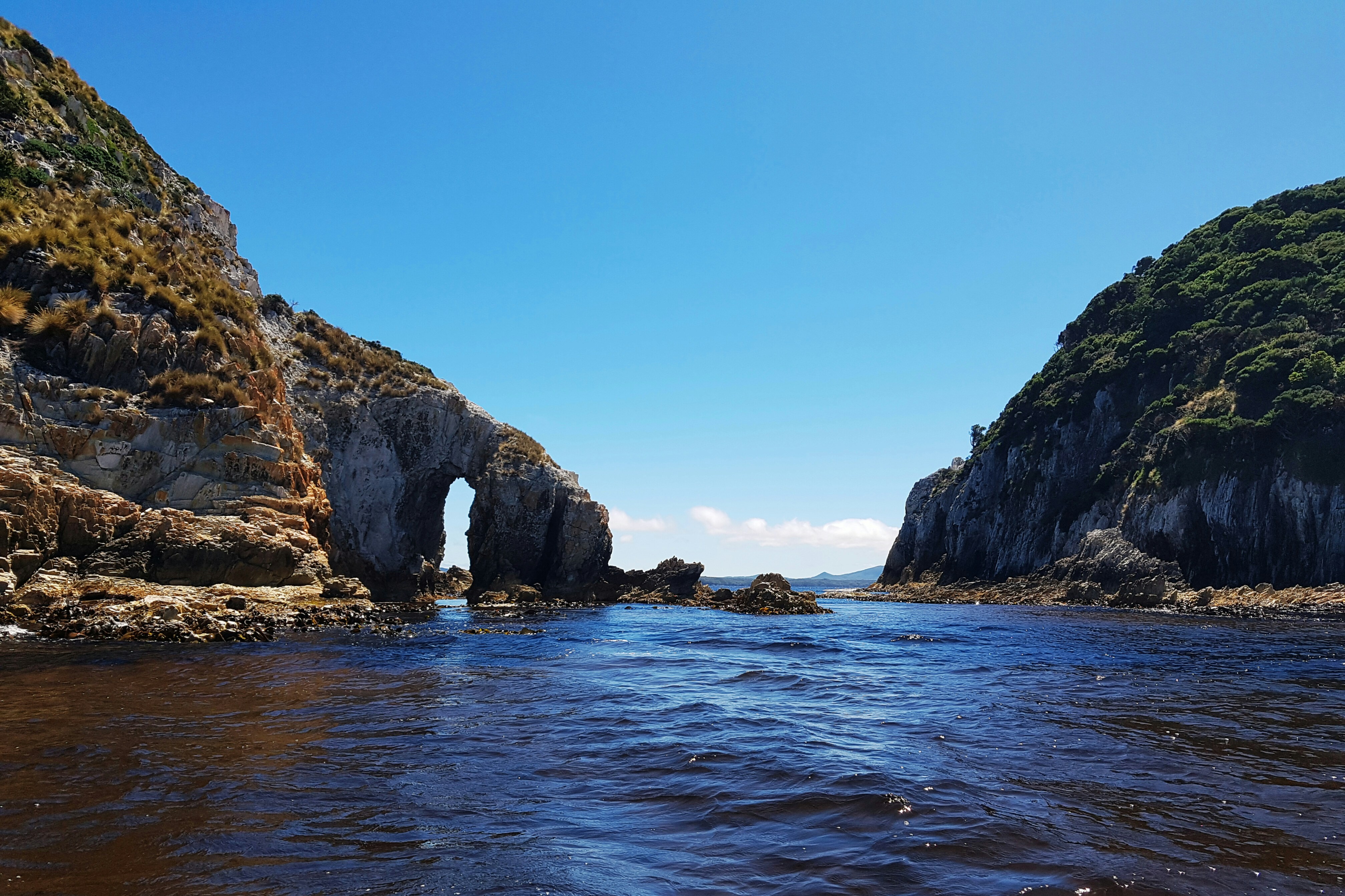 ein Gewässer mit einem Felsbogen in der Mitte