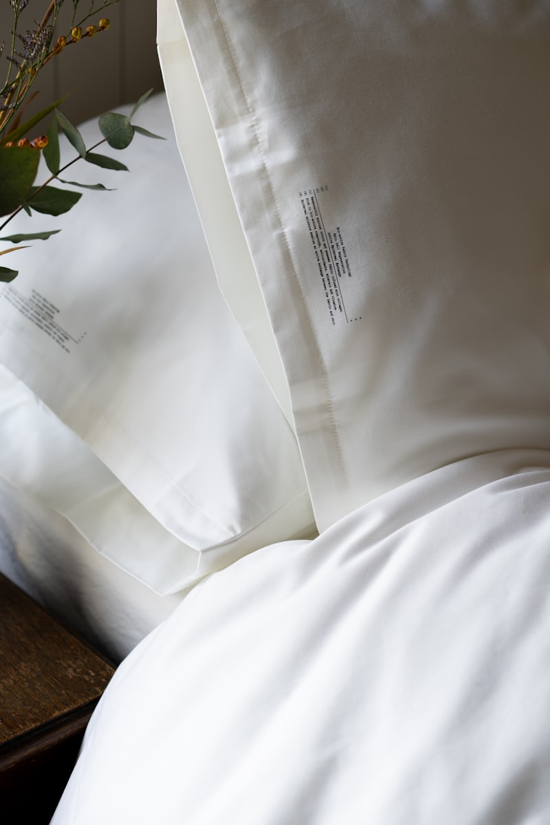 Close-up of white cotton pillowcases on stacked bed pillows