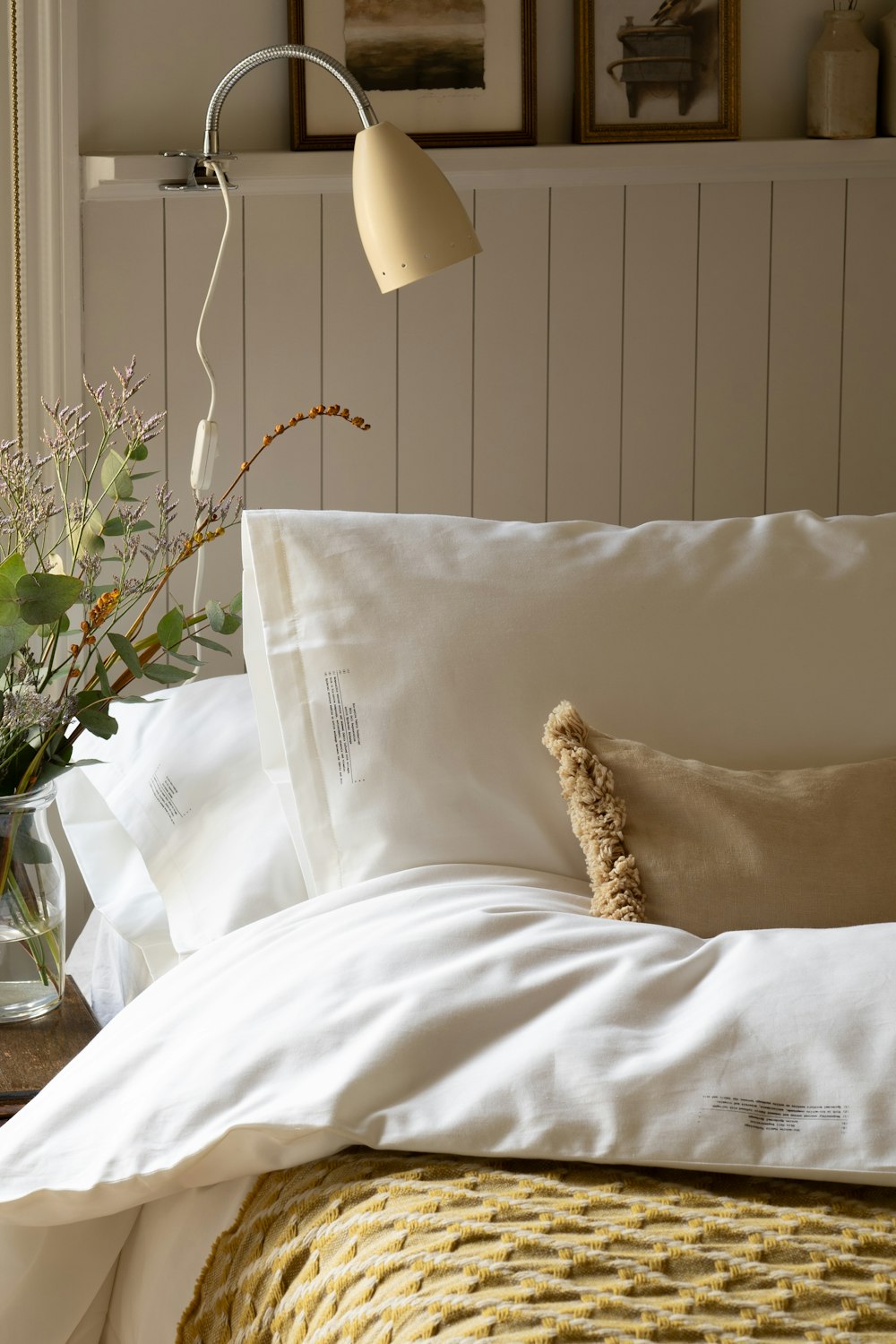 a bed with a white comforter and pillows