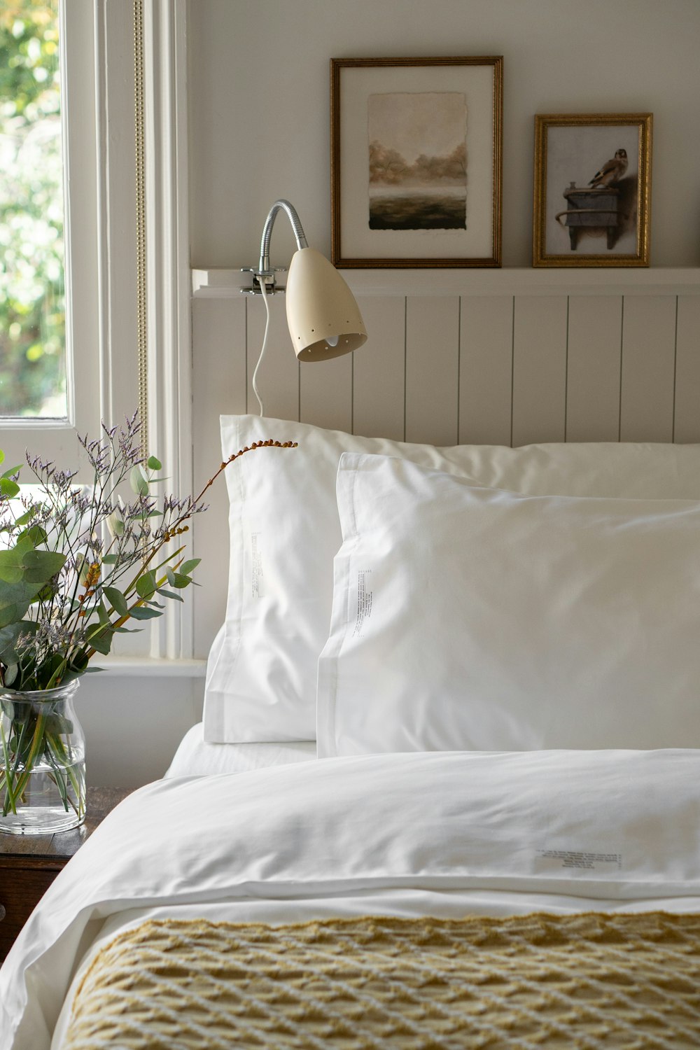 a bed with a white comforter and pillows