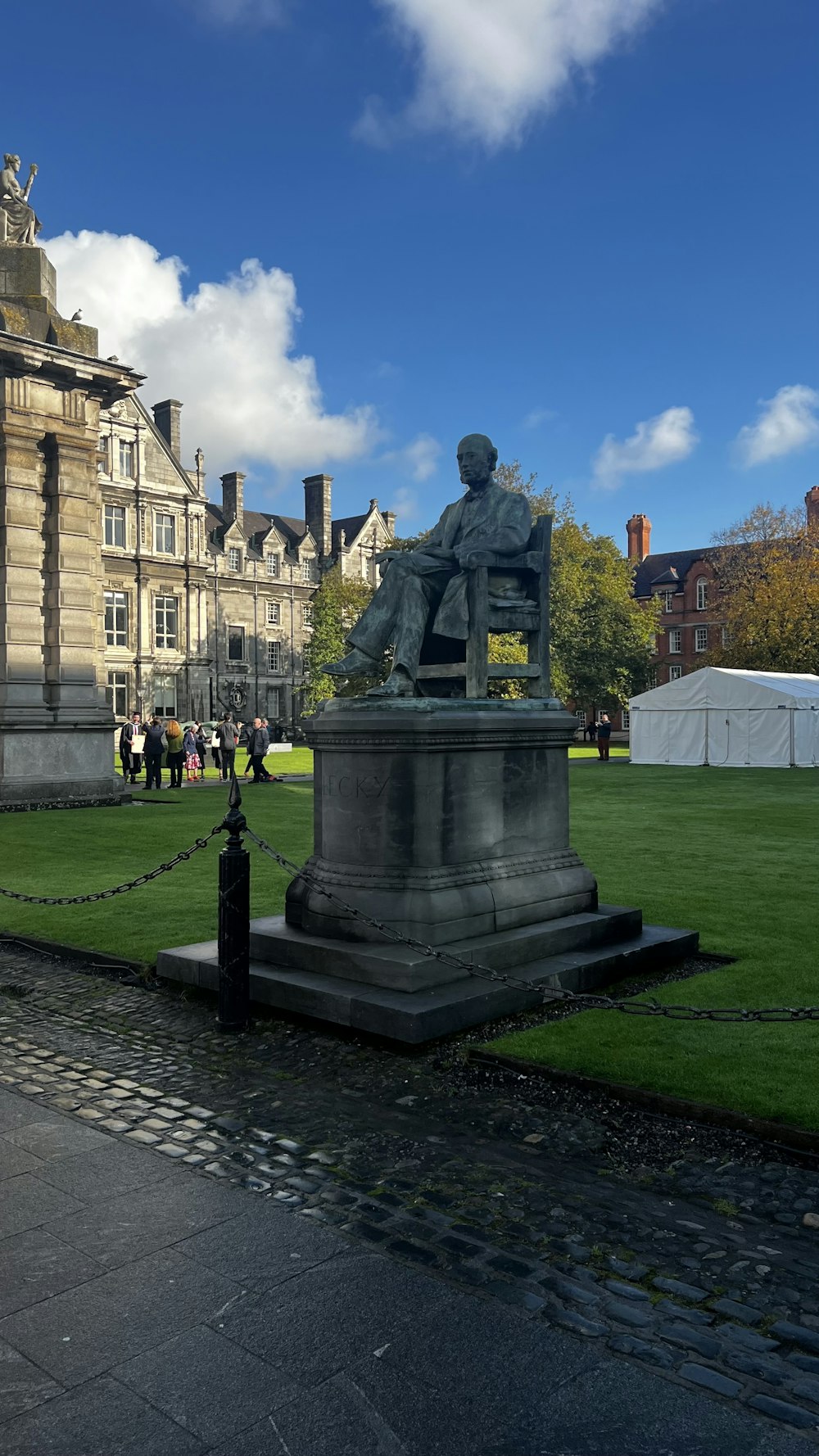 a statue of a man sitting on top of a green field