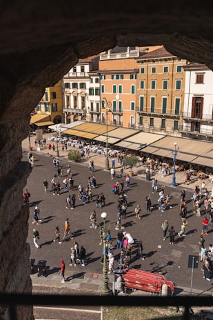 Photo of a lively city square filled with people and colorful buildings.