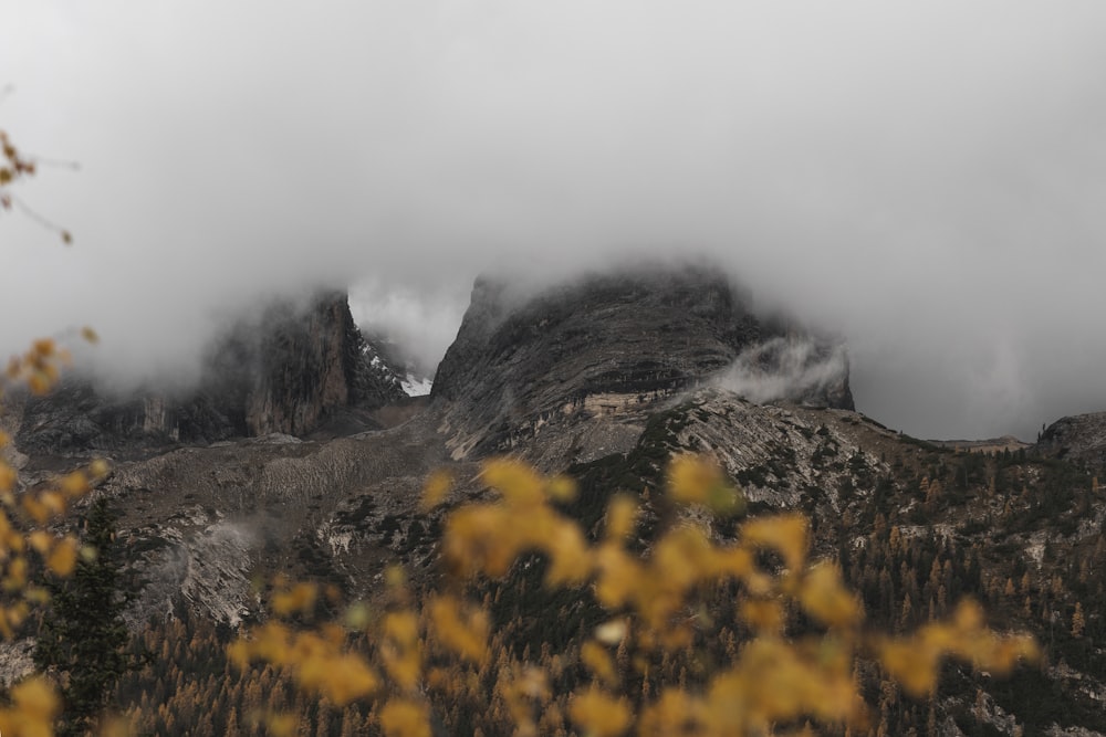 a mountain covered in fog and clouds on a cloudy day