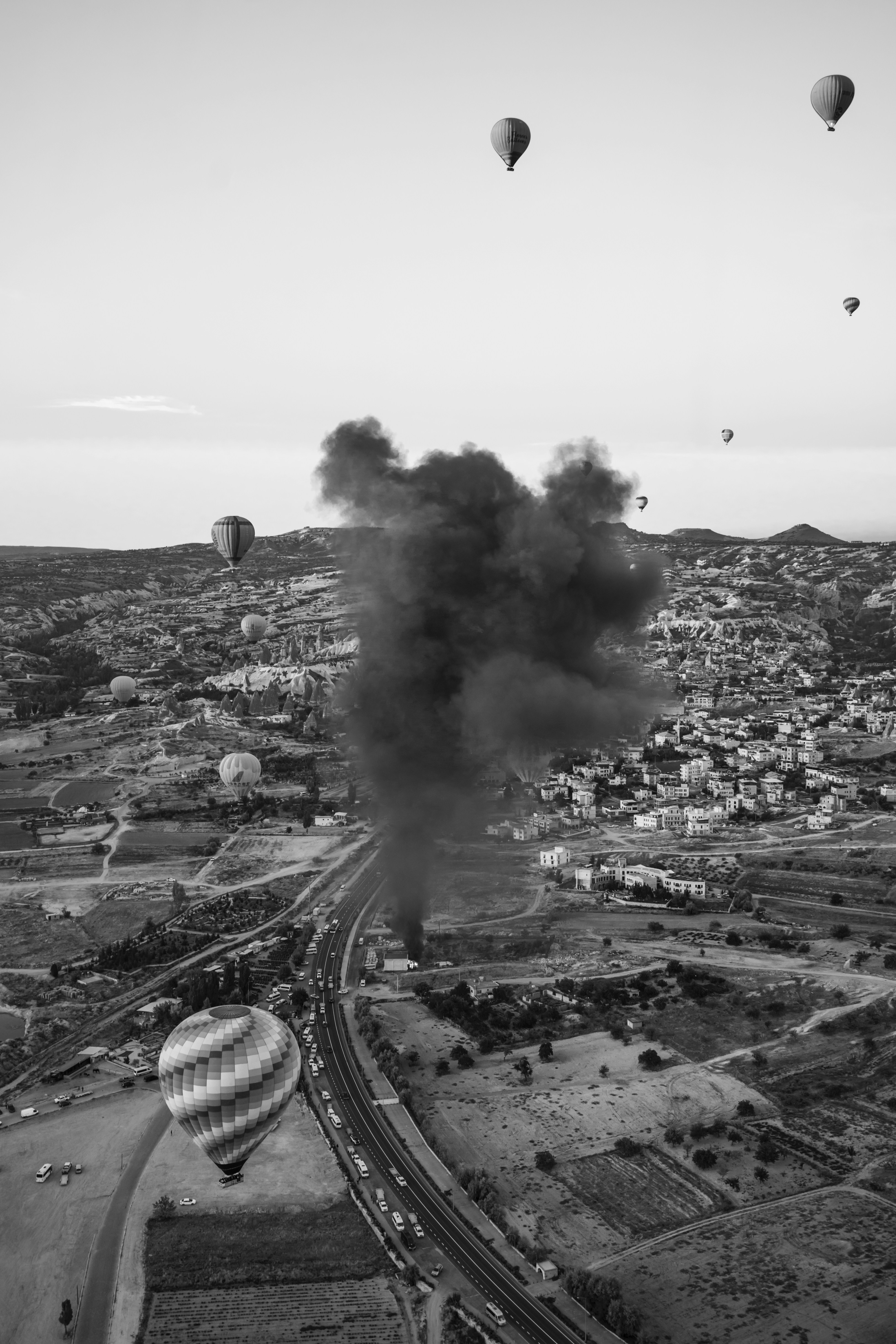a black and white photo of hot air balloons in the sky