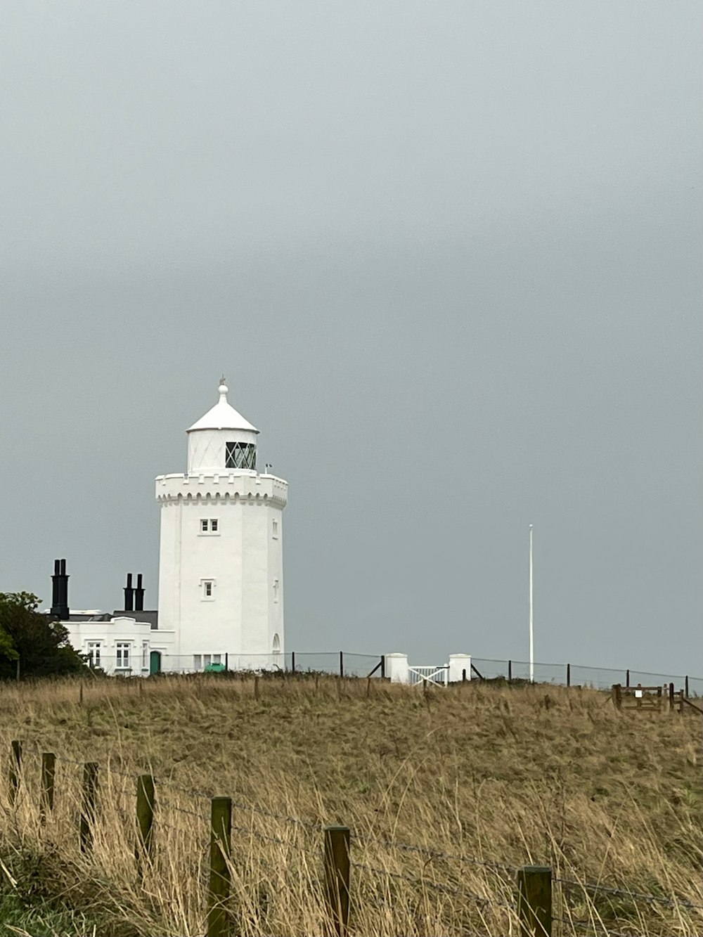 Un phare blanc au sommet d’une colline herbeuse