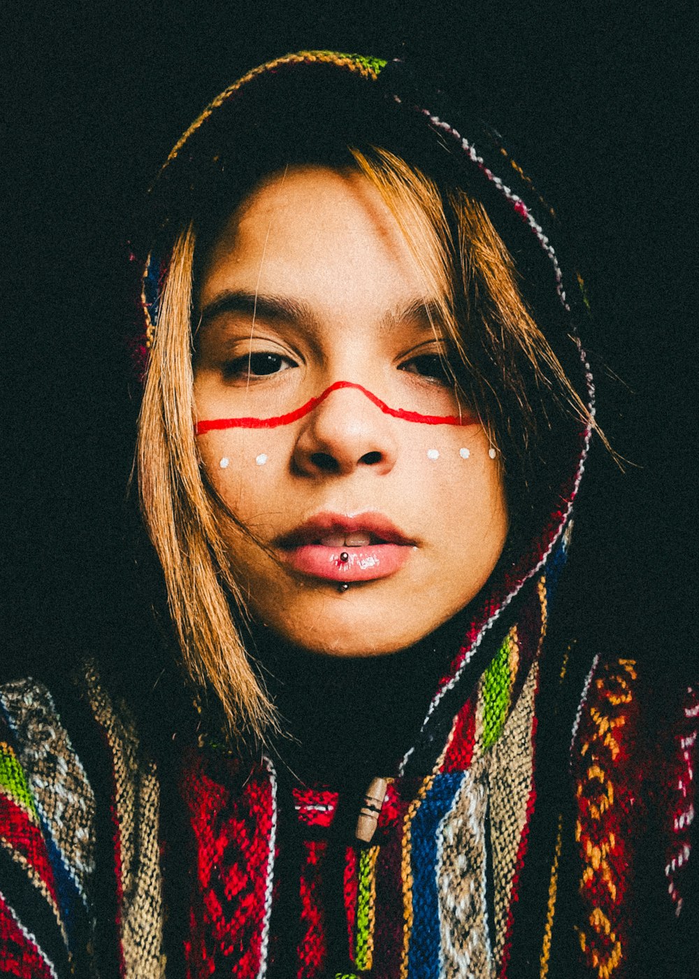 a woman with red lines painted on her face