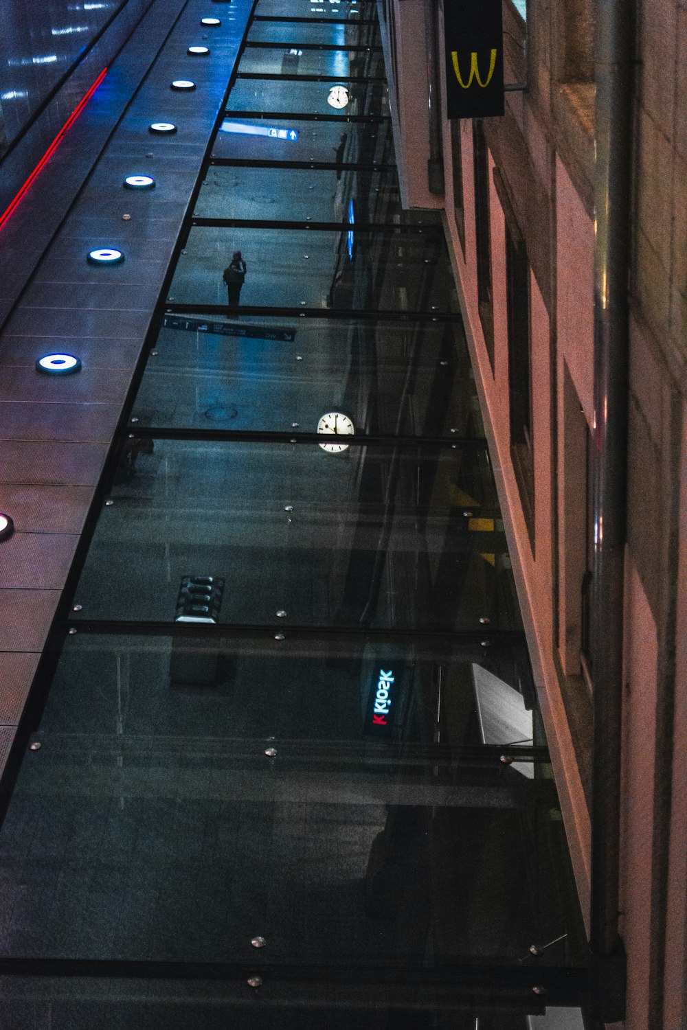 a person walking down a street next to a tall building