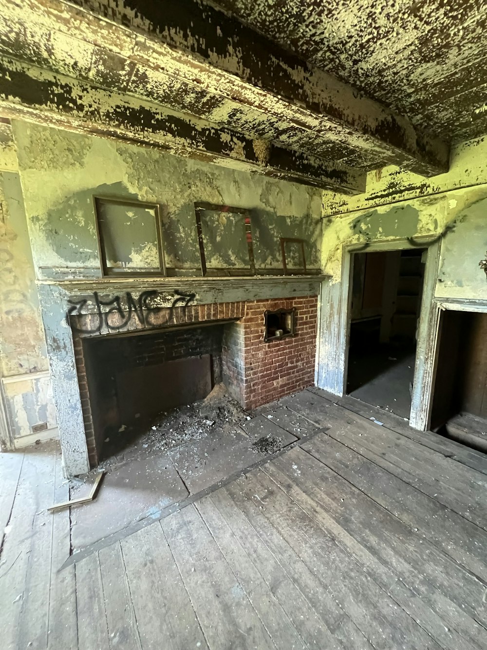 an empty room with a fireplace and graffiti on the walls