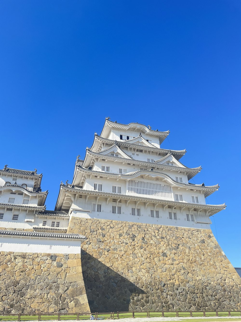 a tall white building sitting on top of a stone wall