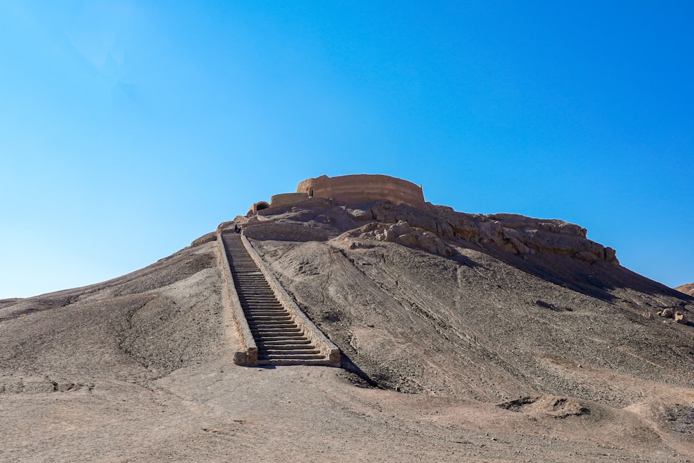 a very tall hill with some stairs going up it