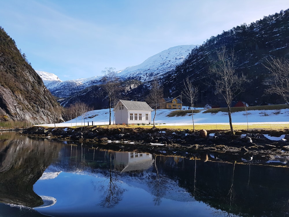 a small house sitting on the shore of a lake