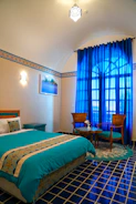 Close-up of elegant wooden bed base with turquoise accents in a bright bedroom.
