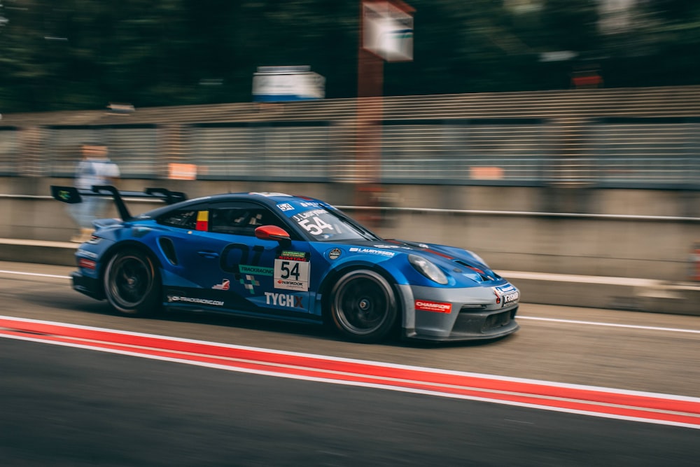 a blue race car driving down a race track