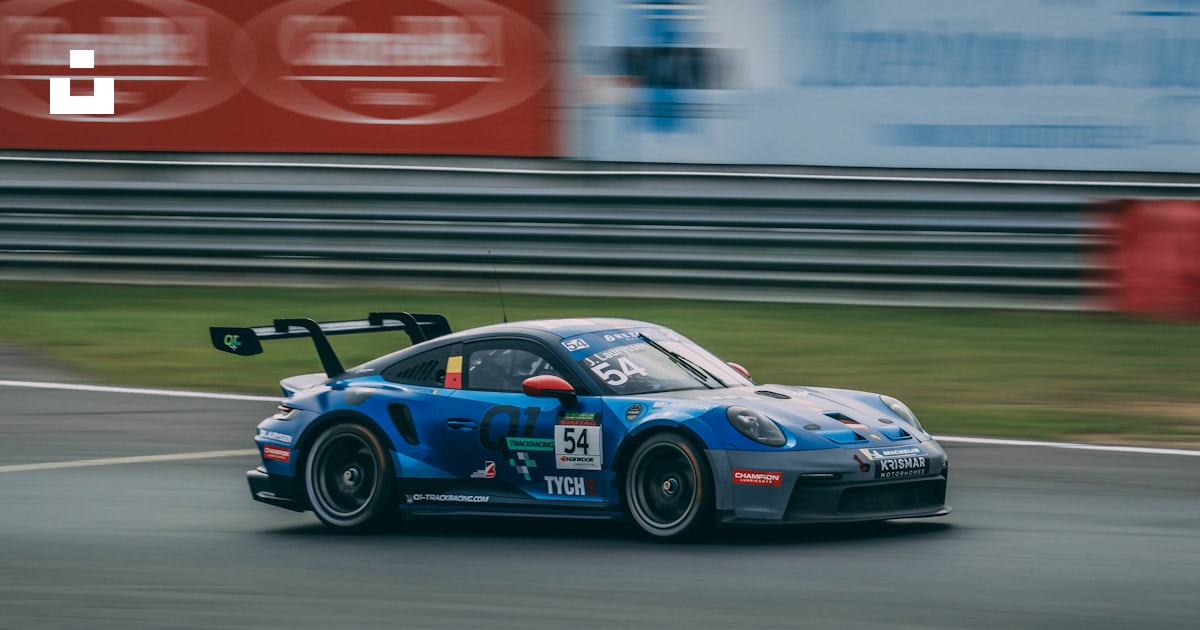 A blue race car driving down a race track photo – Free Terlaemen Image ...