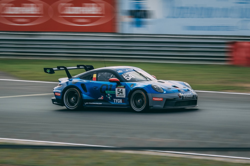 a blue race car driving down a race track