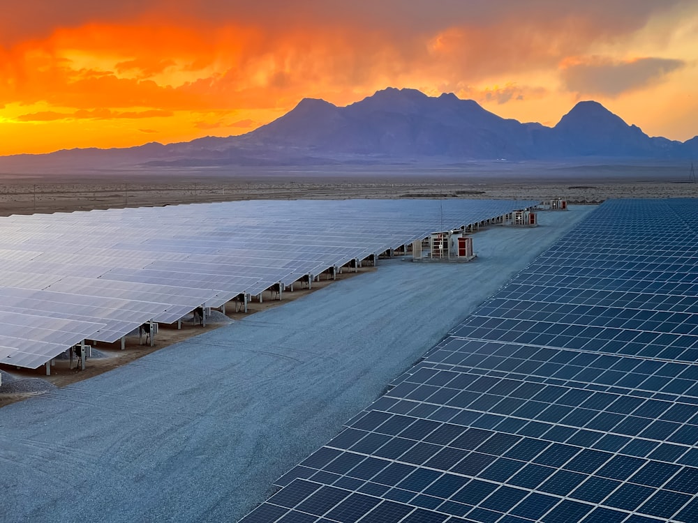 a row of solar panels sitting on top of a dirt field