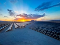 the sun is setting over the roof of a building