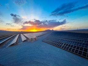 the sun is setting over the roof of a building