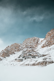 Snow-capped mountains of Ladakh with a Buddhist monastery perched on a cliff