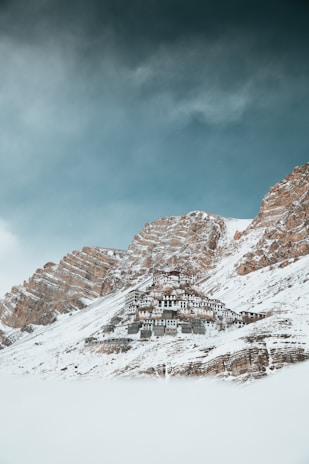 Snow-capped mountains framing a peaceful monastery in Ladakh.