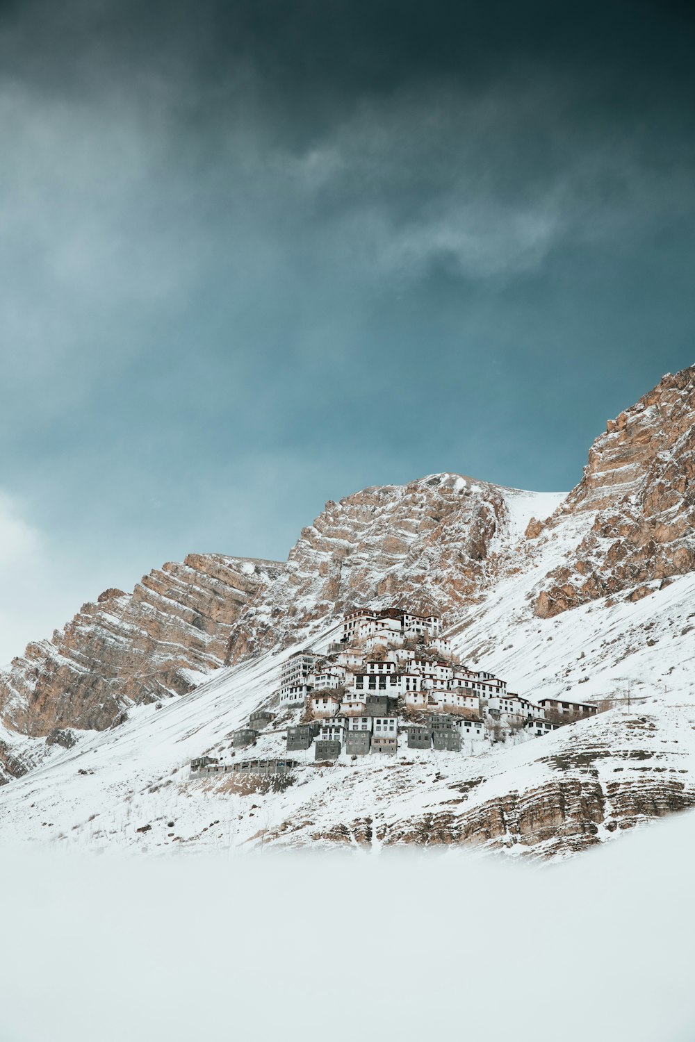 a snow covered mountain with a building on top of it