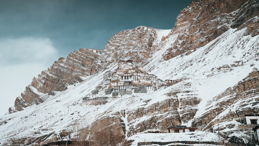 a snow covered mountain with a building on top of it