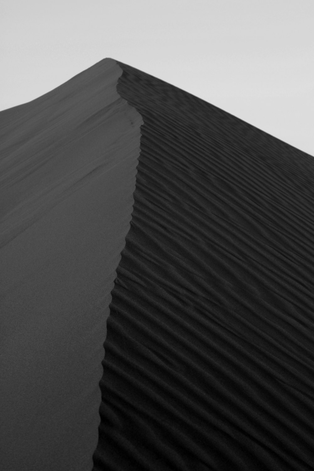 a black and white photo of a sand dune