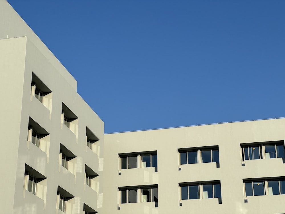 a white building with windows and a blue sky in the background