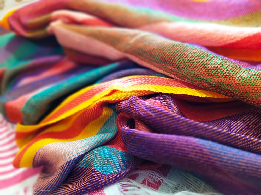 a pile of multicolored scarves sitting on top of a table