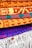 A collection of intricately patterned, colorful woven rugs is neatly stacked. The rugs feature bold geometric designs with dominant colors including orange, red, and blue. The top rugs are rolled while the bottom ones display fringes on their edges.