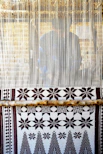 Intricate handwoven Tripuri handloom fabric displayed on a traditional wooden loom.