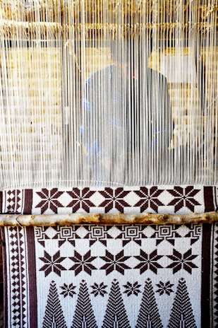 Intricate handwoven Tripuri handloom fabric displayed on a traditional wooden loom.