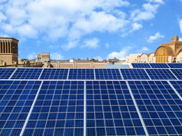 Solar panels gleaming under a bright blue sky on a residential rooftop
