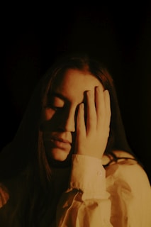 a woman covers her face with her hands